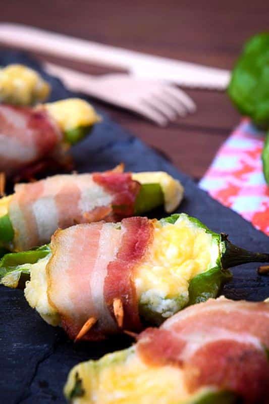 How to Grill Jalapeño Poppers_22 Grilled jalapeno poppers on a black rectangular serving tray.