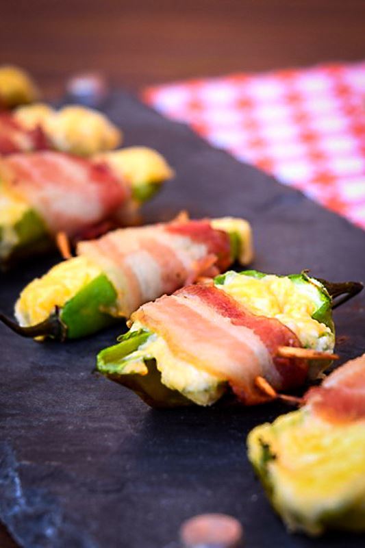 Grilled jalapeno poppers on a black rectangular serving tray.