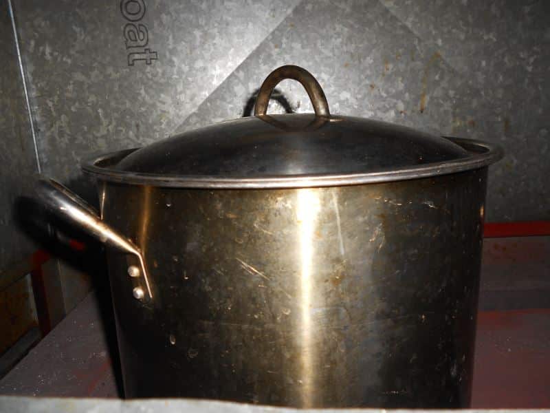 A large pot on top of wood furnace.