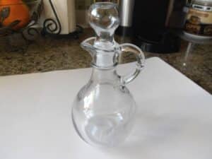 A clear glass bottle on white cutting board.