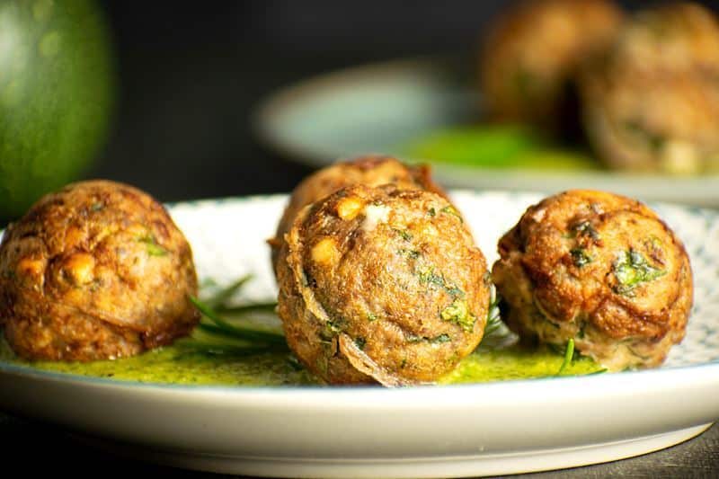 Mediterranean meatballs on a plate with pesto.