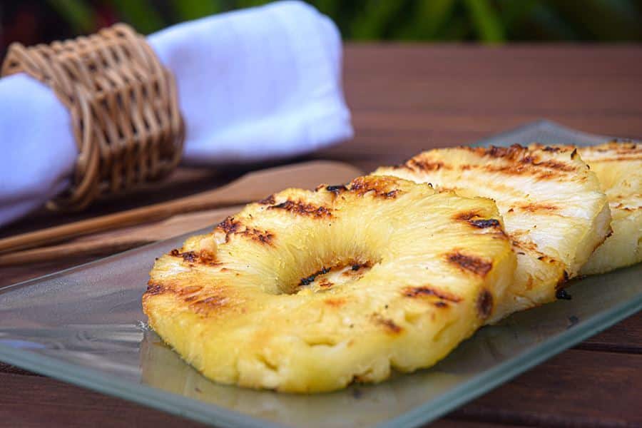 How to Grill Pineapple Slices_13 Grilled pineapple slices on a glass serving plate.
