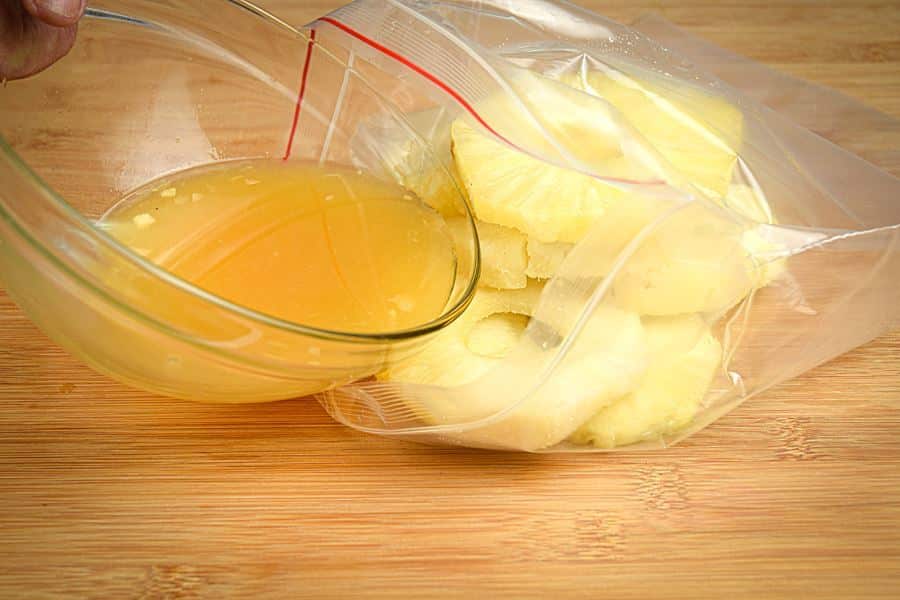 How to Grill Pineapple Slices_5 Pineapple marinade being poured into a ziploc bag filled with pineapple slices.