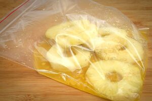 Ziploc bag of pineapple slices and marinade.