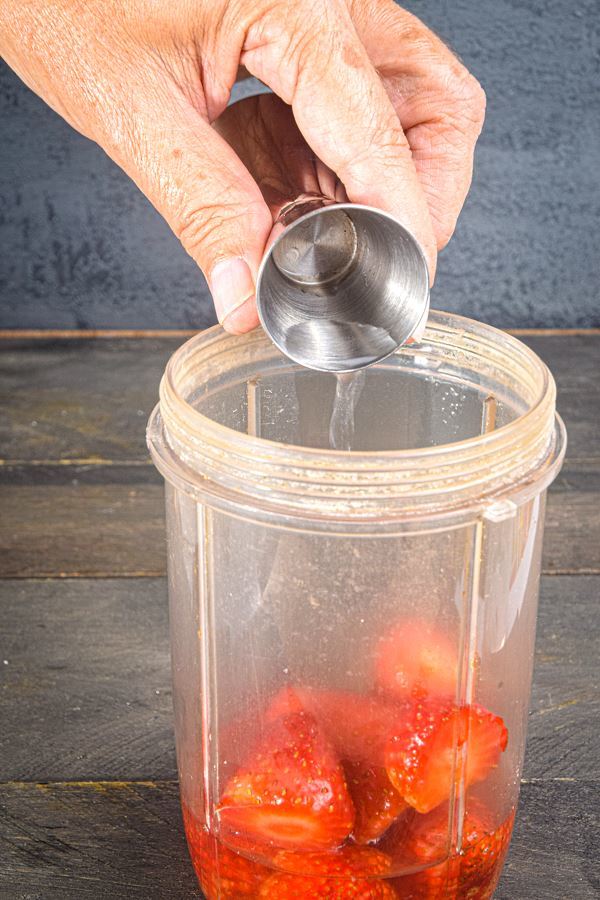 Triple sec being poured into blender jar.
