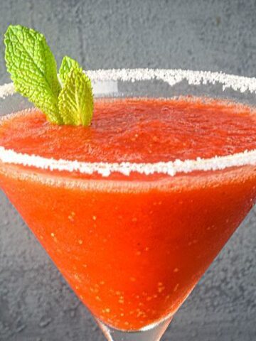 Frozen strawberry margarita with fresh mint leaves.