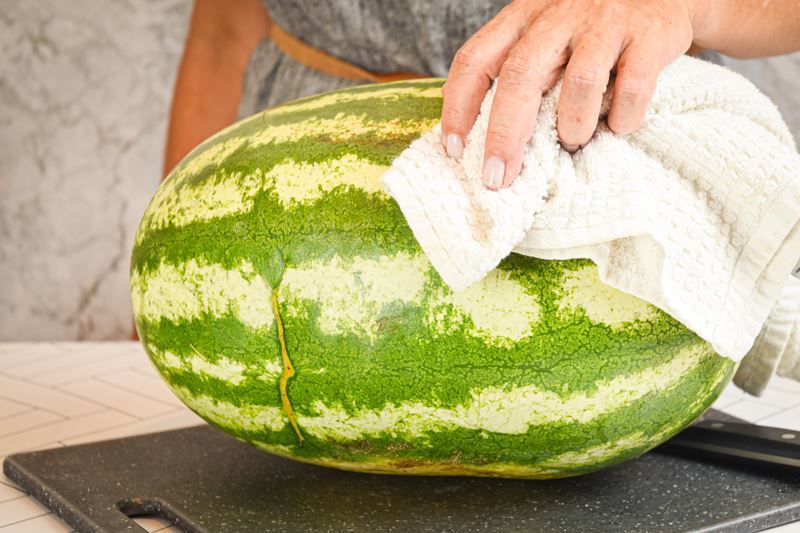 A large watermelon on a cutting board.
