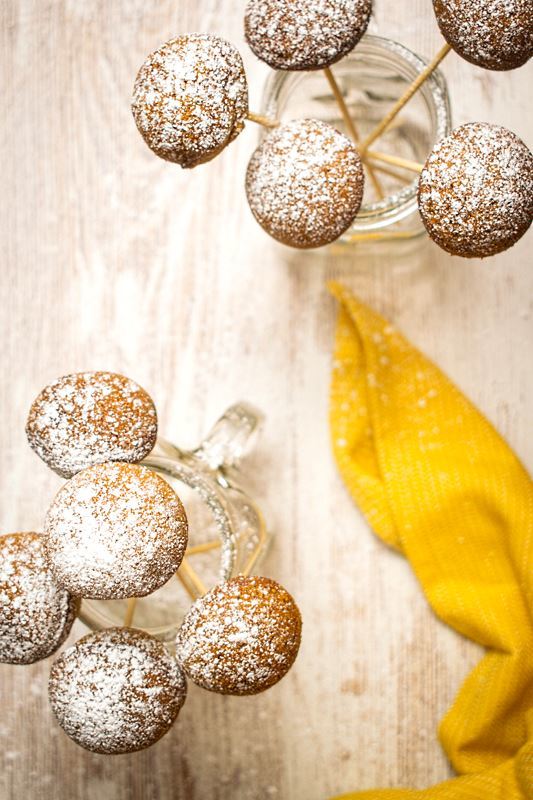 Cake Pop Maker Pumpkin Cake Pops in jars on white background, yellow cloth napkin.