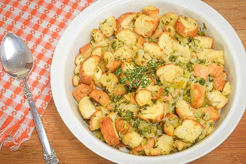 How to Make Stuffing From Scratch_14 Stuffing mix on a plate with a spoon, wooden background.