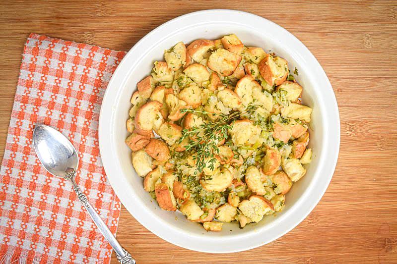 How to Make Stuffing From Scratch_15 Stuffing mix on a plate with a spoon, wooden background.