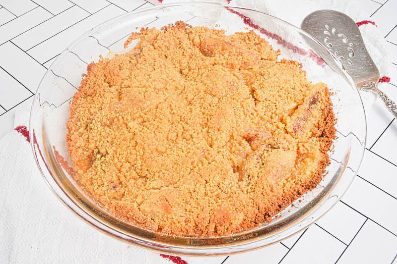 Baked apple crisp in a clear glass bowl.