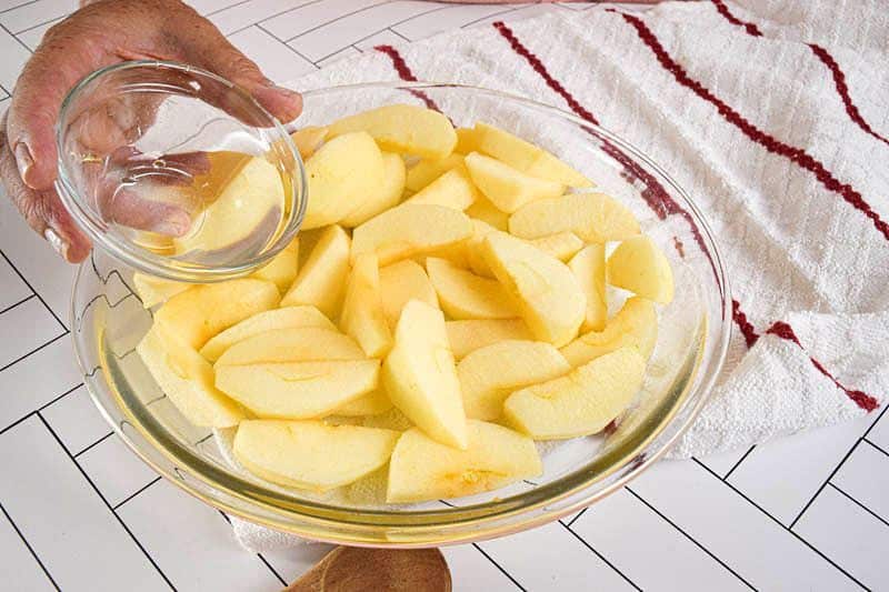 A bowl of sliced apples, white background.