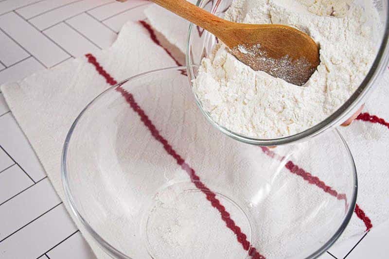 Flour being added to a bowl.