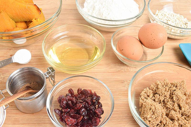 Pumpkin muffin prepped ingredients on a wood background.