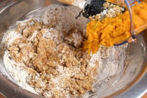A metal bowl of pumpkin muffin batter.