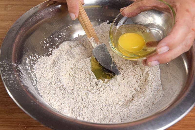 A metal bowl of pumpkin muffin batter being made.