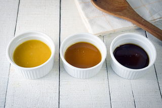 3 colors of roux in ramekins on white wooden background.