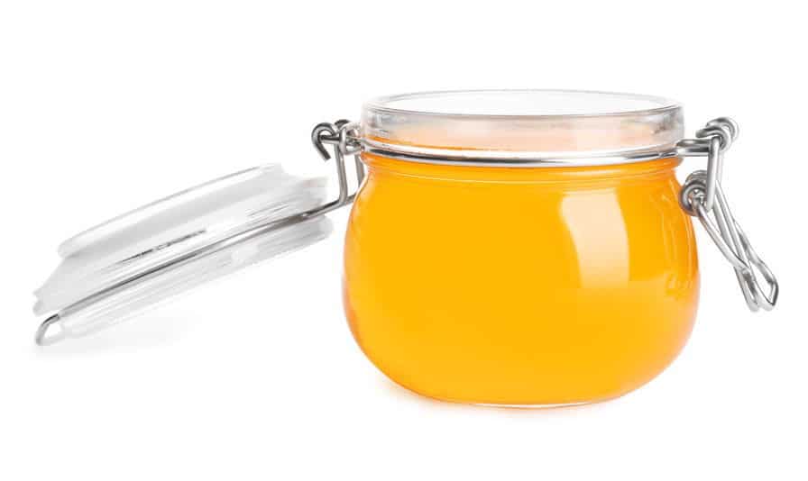 Clear jelly in a jar, white background.