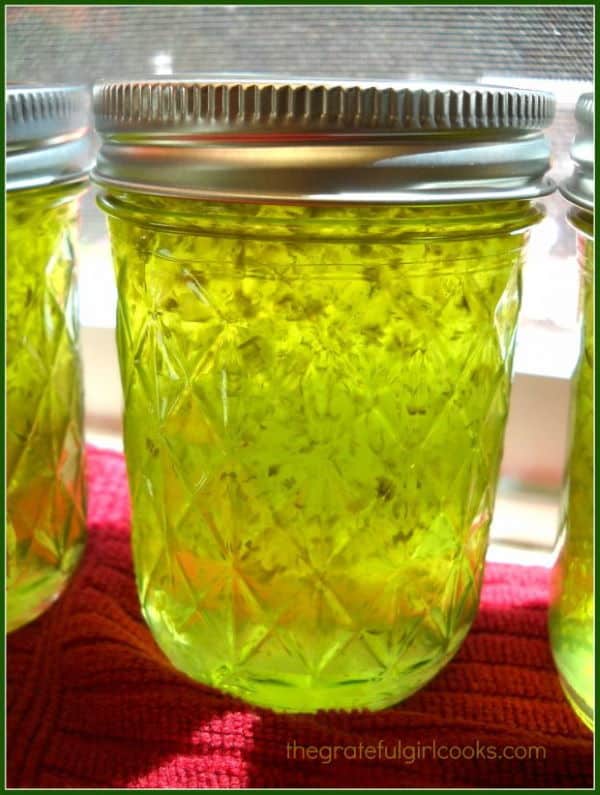 Jalapeno pepper jelly in a small jar, red cloth underneath.