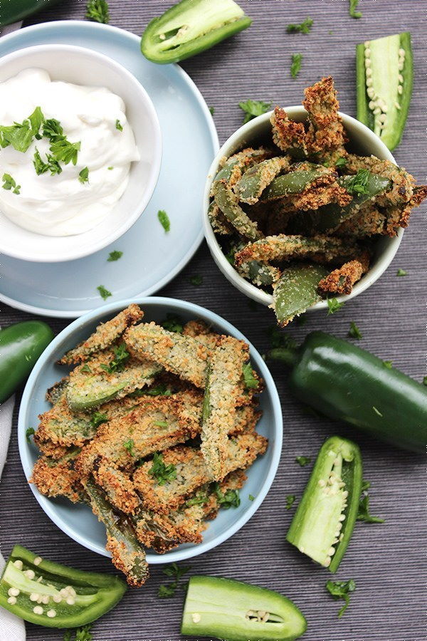 Jalapeno fries in two white bowls, creamy dip on the side.