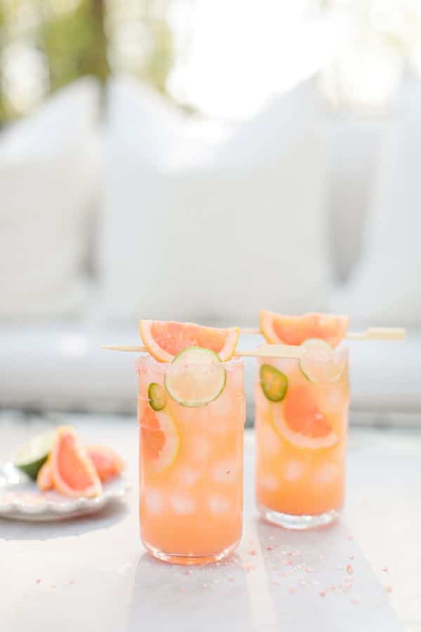 2 glasses of grapefruit jalapeno cocktails, light background.