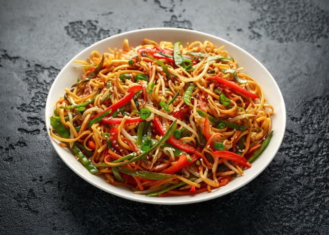 Chow mein noodles Chow mein, noodles and vegetables dish with wooden chopsticks.