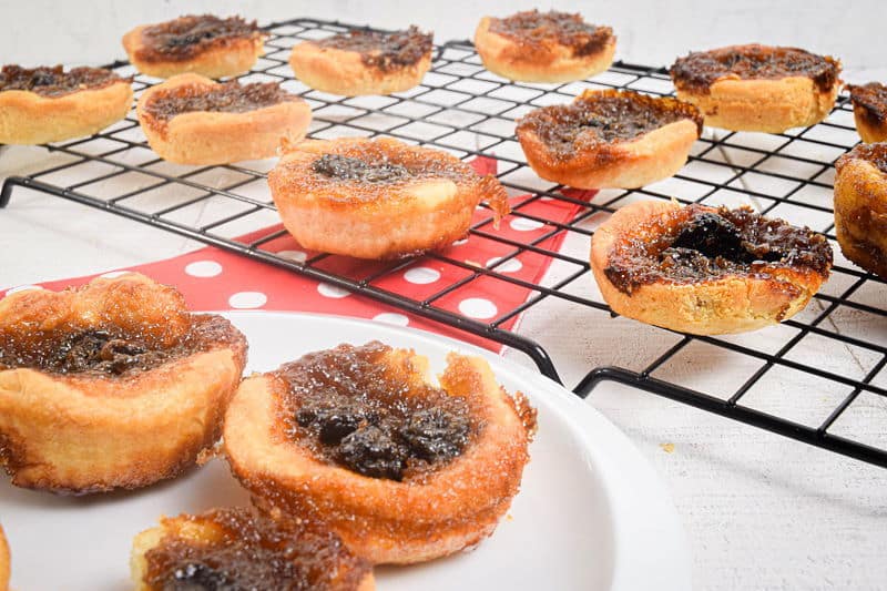 Butter tarts on a white plate and baking rack.