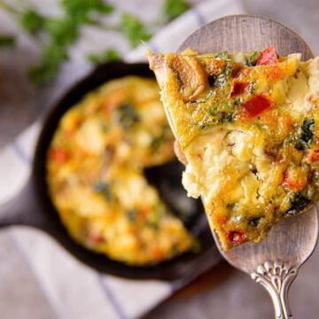 A piece of Electric Skillet Vegetable and Goat Cheese Frittata on a pie server.