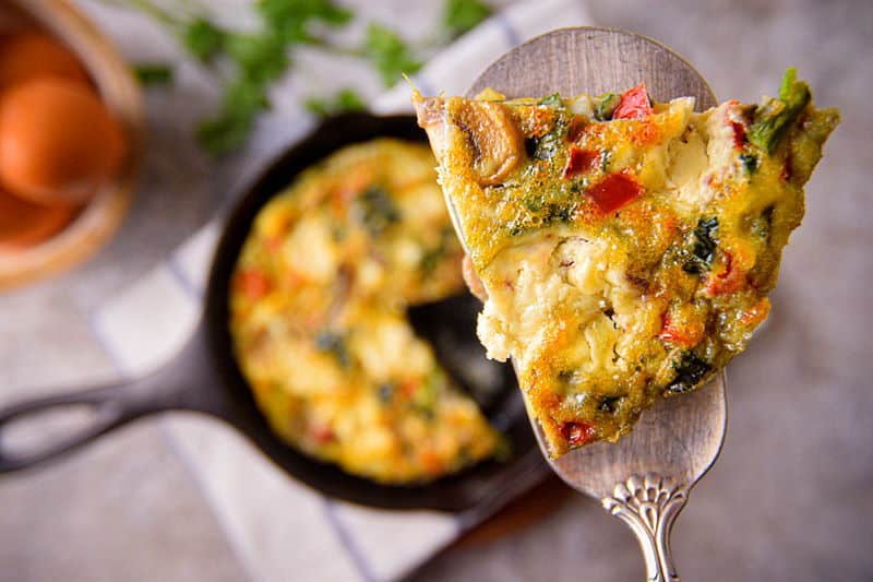 A piece of Electric Skillet Vegetable and Goat Cheese Frittata on a pie server.