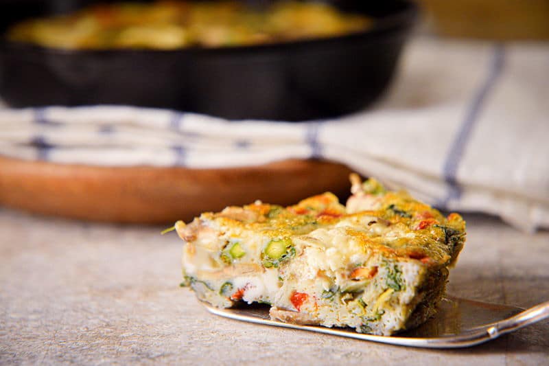 A piece of Electric Skillet Vegetable and Goat Cheese Frittata on a pie server.