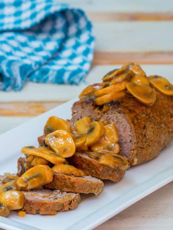 Meatloaf covered in a mushroom sauce on a serving dish.