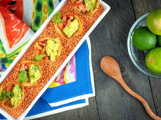 Mexican Tortilla Baskets on a serving tray with a bowl of limes and wooden spoon.