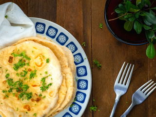 Pumpkin & Garlic Naan Bread piled on a plate.