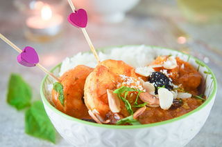 Shrimp curry in a white bowl with pink heart toothpicks.