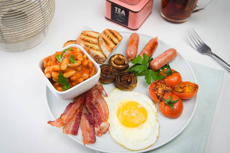 Electric Skillet Full English Breakfast on a white plate, tea on the side.