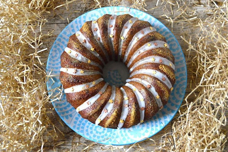 Marzipan bundt cake on blue plate, wooden background.