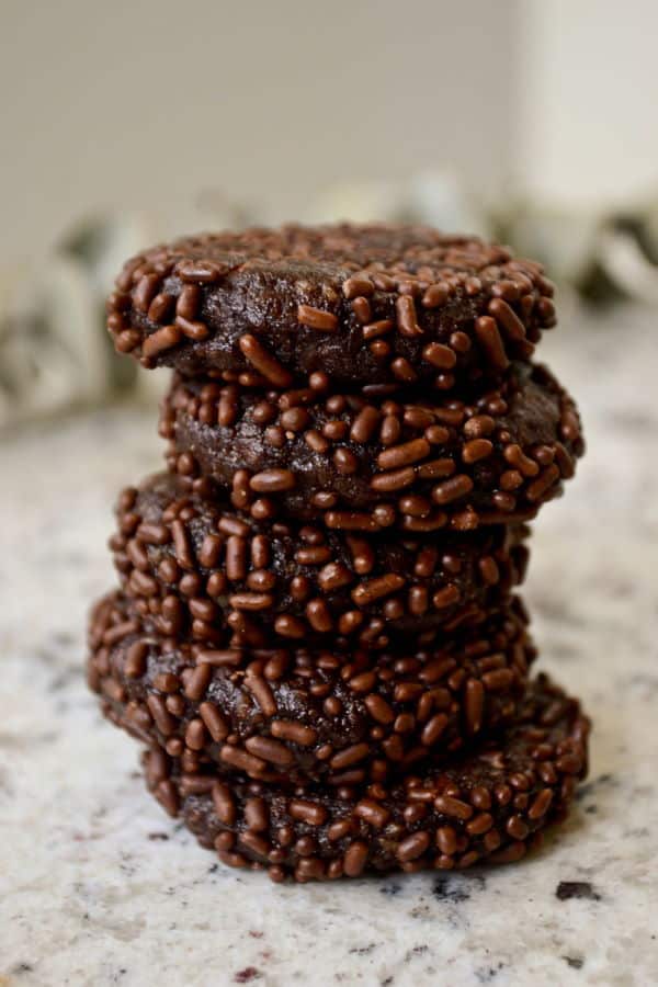 Chocolate marzipan discs with chocolate sprinkles stacked.