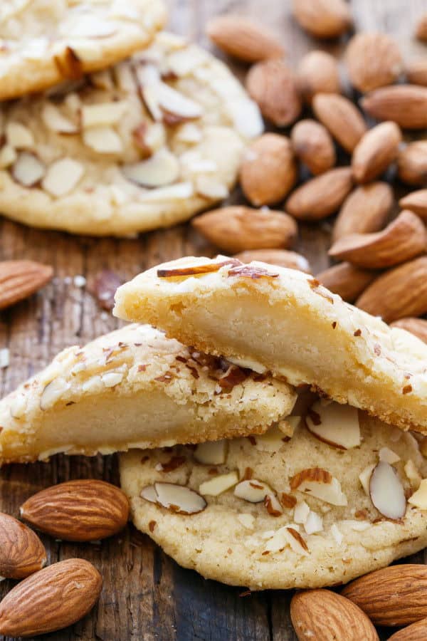 Cookies filled with marzipan, almonds scattered around.