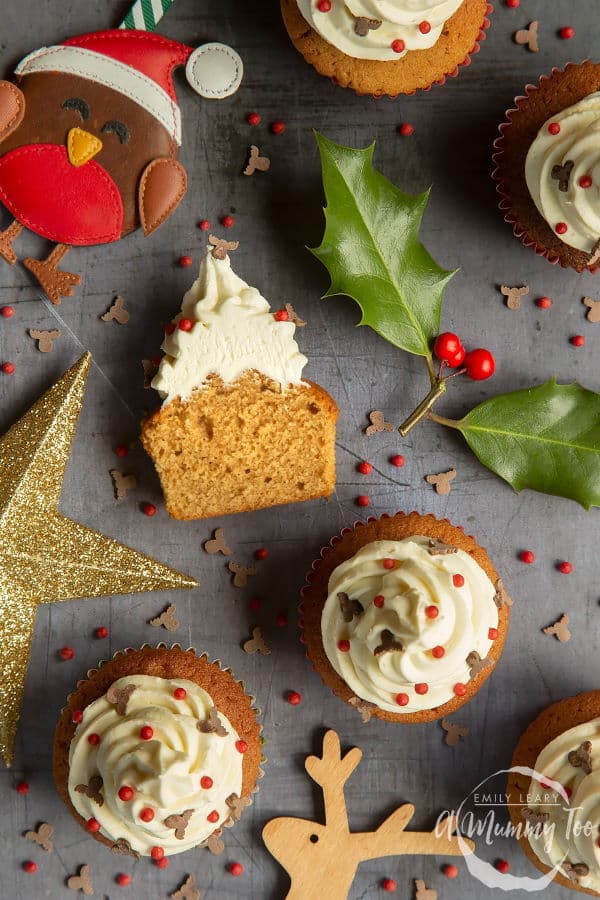 Marzipcan cupcakes with Christmas decorations on grey background.