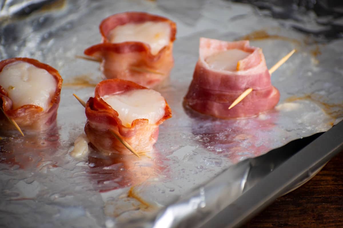 Scallops wrapped in bacon with toothpicks.