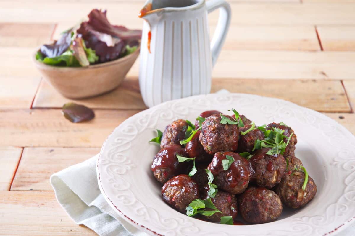 Bison meatballs with BBQ sauce on white plate.