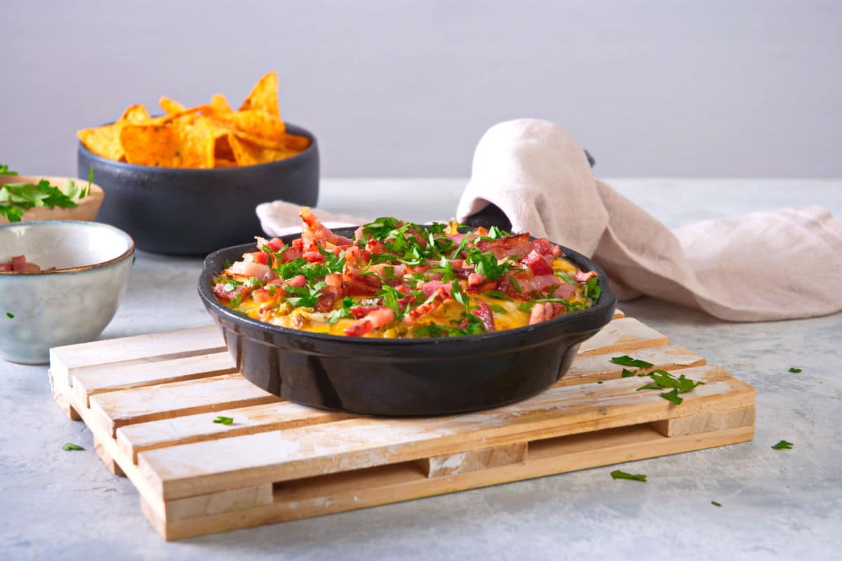 Bison dip in cast iron skillet with chips in the background.