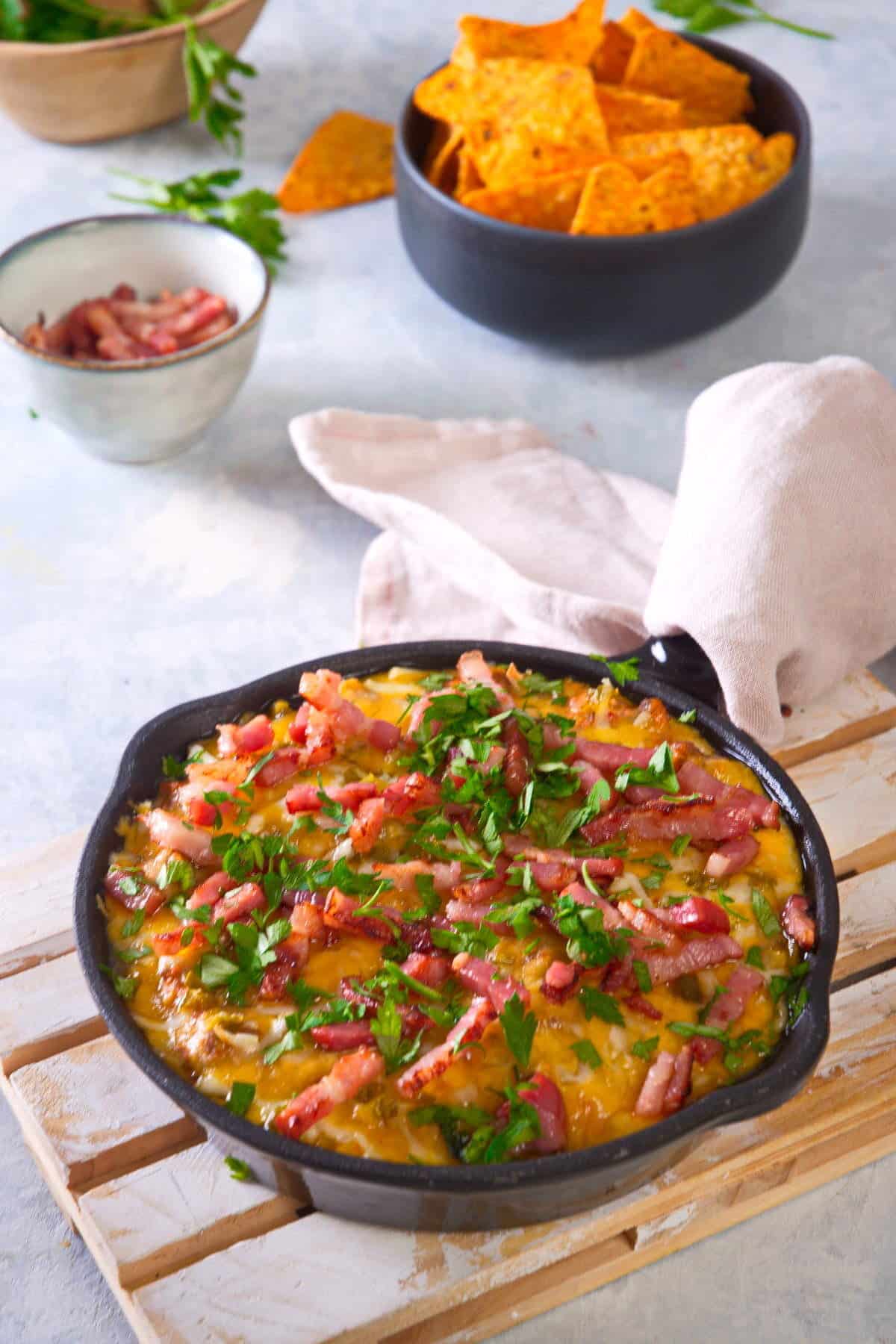 Bison dip in cast iron skillet with chips in the background.