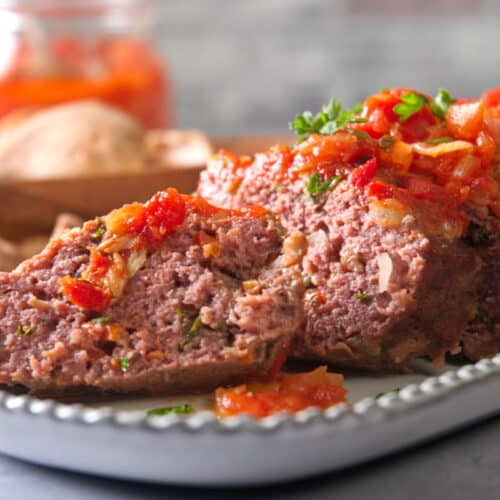 Bison meatloaf sliced on white serving dish.