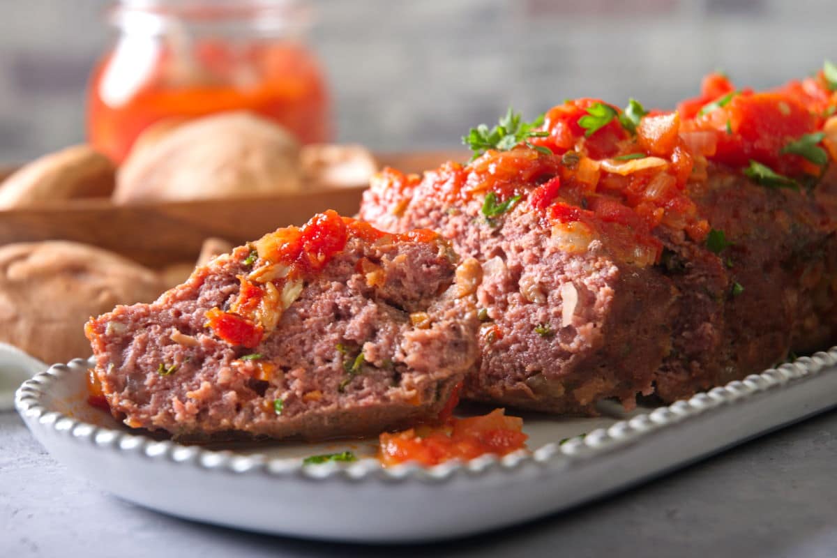 Bison meatloaf sliced on white serving dish.