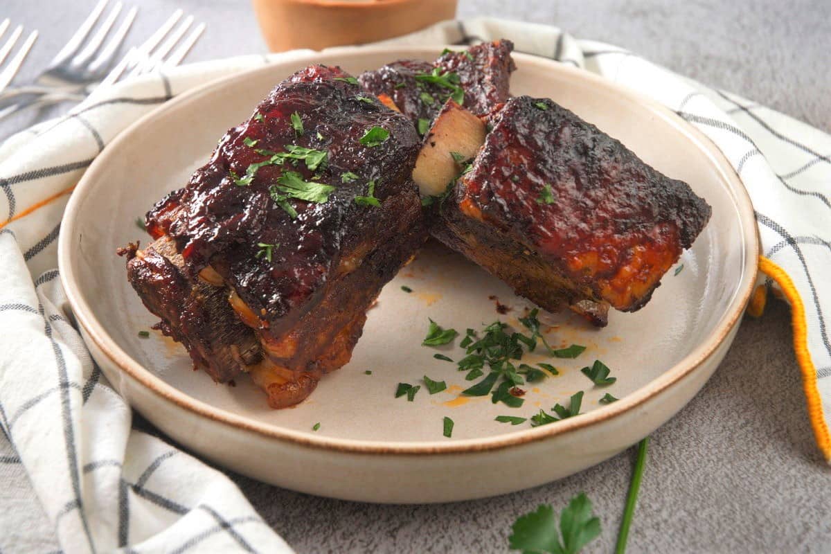 BBQ bison short ribs in white dish.