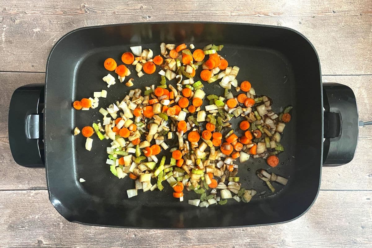 Veggies in electric skillet frying.