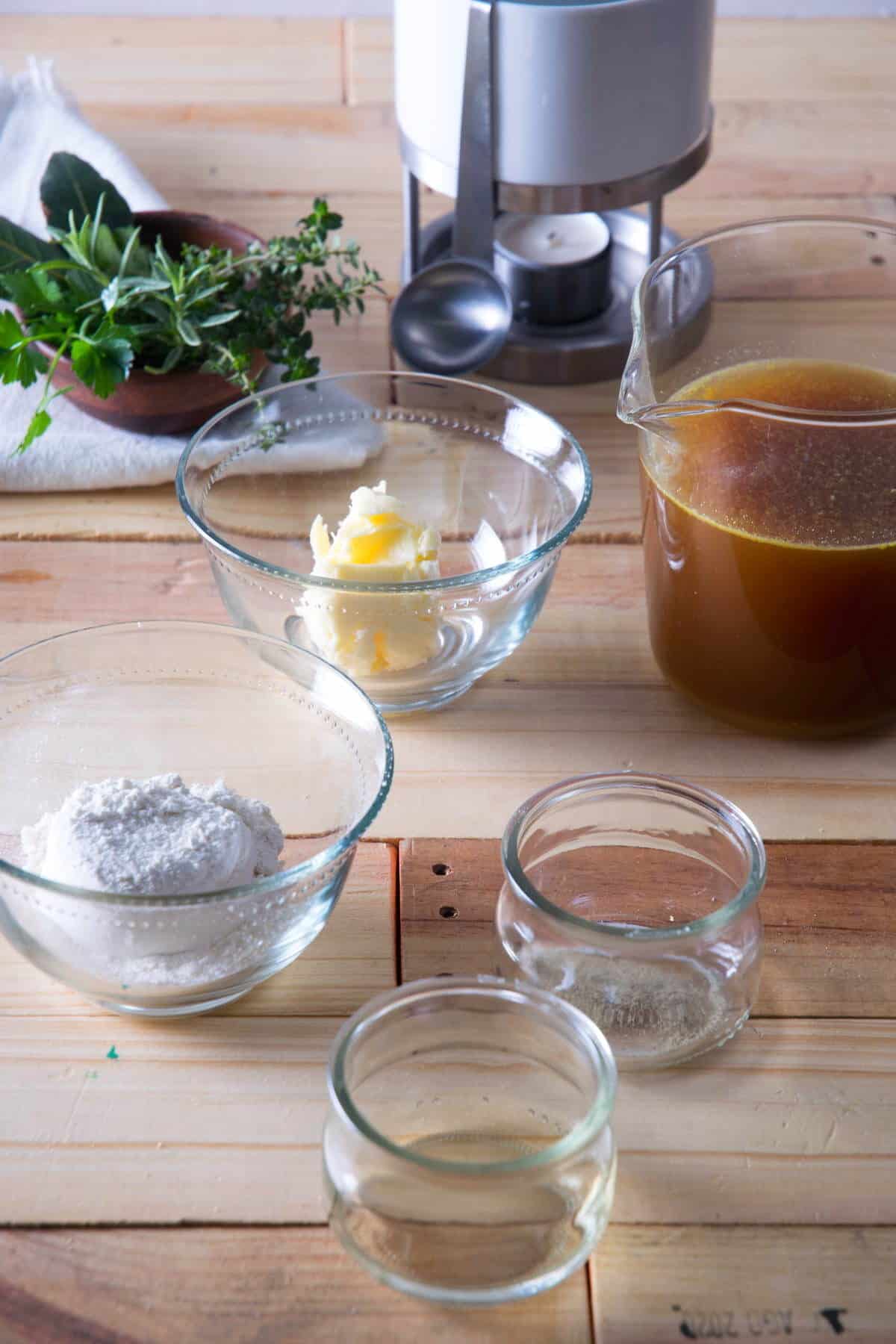 Brown gravy ingredients prepped on wooden background.