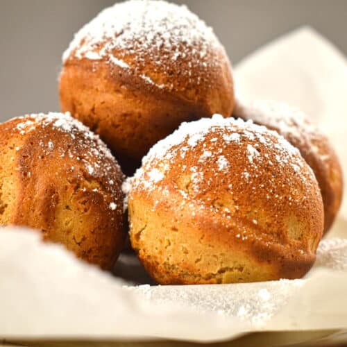 Gingerbread cake balls on parchment, covered in powdered sugar close up.