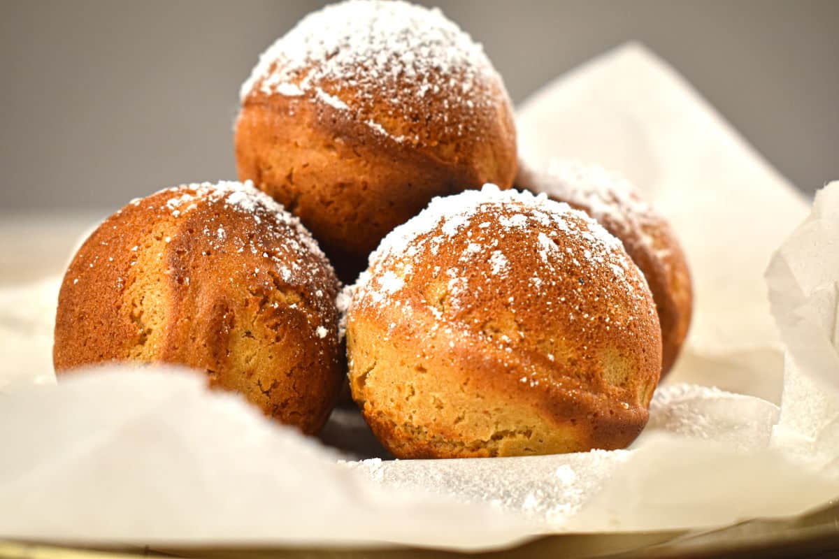 Gingerbread cake balls on parchment, covered in powdered sugar close up.